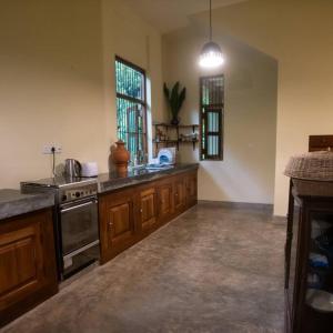 une grande cuisine avec des placards en bois et une cuisinière dans l'établissement Weralugama Forest House, 