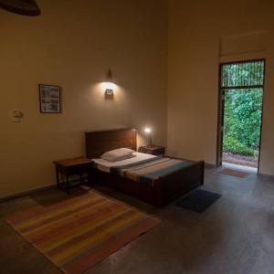- une chambre avec un grand lit et une fenêtre dans l'établissement Weralugama Forest House, 