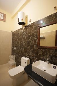 a bathroom with a toilet and a sink and a mirror at Rajputana Heritage Ranthambhore Home Stay in Sawāi Mādhopur +54 photos