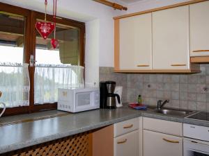 a kitchen with a sink and a microwave at Cosy holiday flat in Pinzgau in Bramberg am Wildkogel