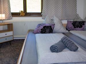 - une chambre avec un grand lit et des oreillers violets dans l'établissement Holiday flat with National Park Card included, à Bramberg am Wildkogel