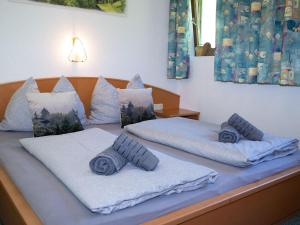 a bed with two pillows on top of it at Cosy holiday flat in Pinzgau in Bramberg am Wildkogel