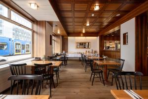 a dining room with wooden tables and chairs at Olympia Hotel Zurich in Zurich