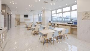 a cafeteria with tables and chairs in a building at Toyoko Inn Tenri Ekimae in Tenri