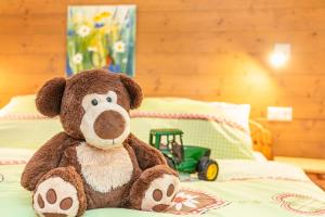 a teddy bear sitting on top of a bed at Stanglehen in Mittersill