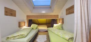 BürchenにあるFortunaのベッド2台と窓が備わる小さな客室です。