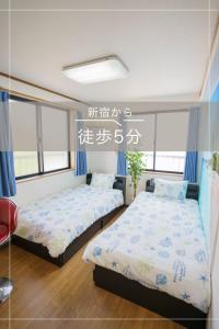 Habitación con 2 camas y un cartel en la pared en BURan House, en Tokio