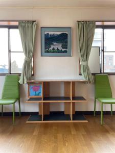 una sala de espera con 2 sillas verdes y un escritorio en 今市STAY - NIKKO private house rental only 5 min to station en Nikko