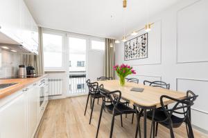 een keuken en eetkamer met een houten tafel en stoelen bij Apartament Grzybowska Premium by Your Freedom in Warschau