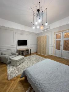 a living room with a bed and a chandelier at Barty downtown apart 2 in Timişoara
