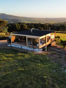 a house on a hill with a man standing on the roof at Hemel 'N Aarde Stud in Hermanus