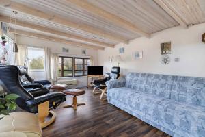 sala de estar con sofá azul y sillas en Charming Cottage In Mesinge, en Mesinge