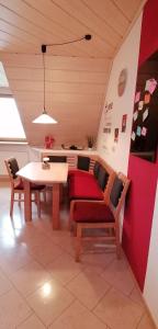 uma sala de estar com uma mesa e um sofá vermelho em Ferienwohnung Dörfler em Hollfeld