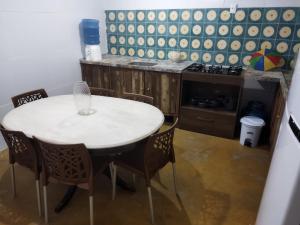 a kitchen with a white table and chairs in a room at Casa Prudente in Olinda