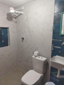 La salle de bains blanche est pourvue de toilettes et d'un lavabo. dans l'établissement Casa Prudente, à Olinda