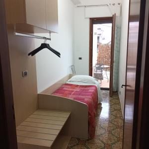 Angolo Fiorito في أَجيرولا: غرفة نوم بسرير ومقعد في غرفة