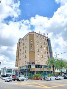 un gran edificio con coches estacionados frente a él en Koho Hotel - Johor Bahru, en Johor Bahru