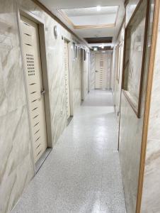 a hallway with white doors and tile floors and a corridor at Cony house in Seoul
