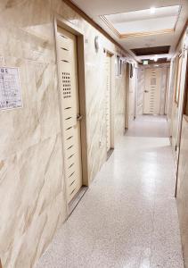 a corridor in a hospital with marble walls and doors at Cony house in Seoul