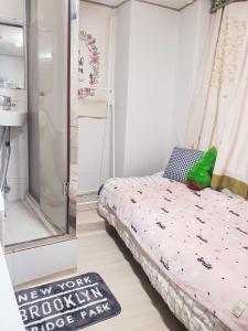a small bedroom with a bed and a shower at Cony house in Seoul