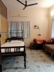 um quarto com 2 camas e uma ventoinha de tecto em Taj Mahal Hotel em Cochin