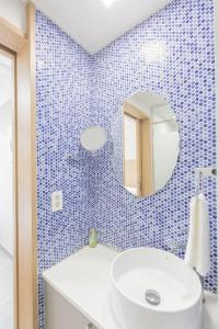 a blue tiled bathroom with a sink and a mirror at TamnaCounty L101 - DtreeSuite OceanVIew,B&B,BBQ,Pool in Seogwipo