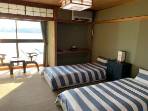 two beds in a room with a view of the ocean at Nojiri Lake Resort in Shinano