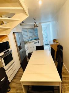 a kitchen with a table and chairs in a room at Charmante maison écologique à 2 pas de Paris in Les Lilas