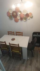 a table with chairs and plates on a wall at Charmante maison écologique à 2 pas de Paris in Les Lilas