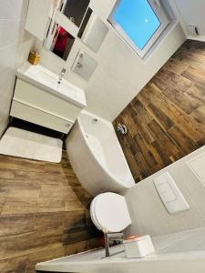 a bathroom with a white toilet and a sink at Charmante maison écologique à 2 pas de Paris in Les Lilas