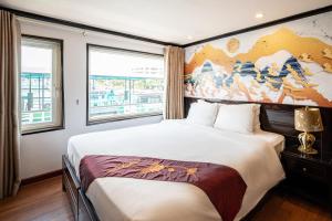 下龍灣的住宿－Dragon Crown Legend Cruise，卧室配有一张大床,墙上挂有绘画作品