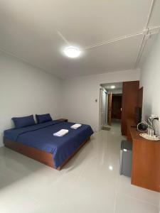 a bedroom with a blue bed and a desk at ศิวพฤกษ์ เพลส in Nonthaburi