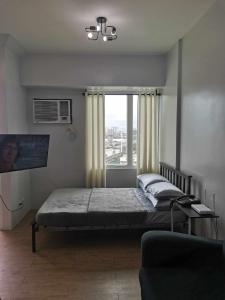 - une chambre avec un lit et une grande fenêtre dans l'établissement Ultimate getaway in Alabang at Anuva Residences, à Manille