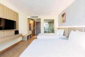 Habitación de hotel con 2 camas y TV de pantalla plana. en Hùng Vương Hotel, en Móng Cái