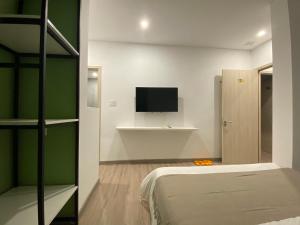 a bedroom with a bed and a flat screen tv at Letters Bà Triệu in Liên Trì (3)