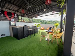 Zimmer mit grünem Gras, Tisch und Stühlen in der Unterkunft Neon Patong in Patong Beach + 37 Fotos