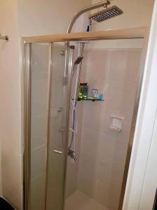 een douche met een glazen deur in de badkamer bij JR Studio Luxe 1824 at Princeton Residences in Manilla