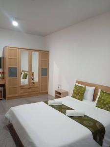 a bedroom with two beds and a cabinet at NOP PLACE BANGNA in Ban Bang Phrao +13 photos