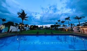 ein großer Pool mit Palmen im Hintergrund in der Unterkunft Lumiere Family Village Dong Tac in Hiếu Xương