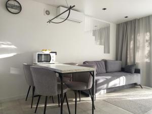 uma sala de jantar com uma mesa e um sofá em New and comfortable apartments em Uzhhorod
