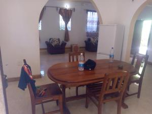 a dining room with a wooden table and chairs at saba saba home stay in Nungwi