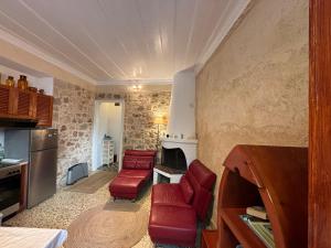 Maison Roxanne & Maisonette in medieval city by Rhodes4vacation في بلدة رودس: غرفة معيشة مع كراسي حمراء ومدفأة