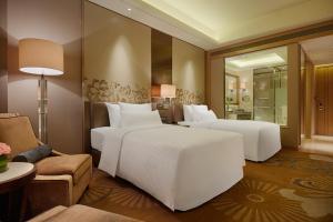 una camera d'albergo con due letti e un divano di Wanda Realm Ningde a Ningde