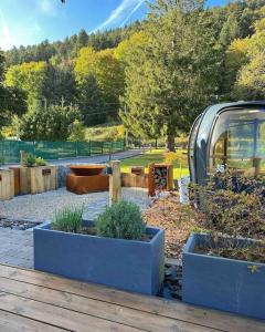 a garden with three blue planters in a park at Chalet Authentique - Insolite - Sauna & Télécabine - Ménage, serviettes, lit fait inclus in Rochesson +14 photos
