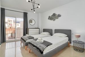 a bedroom with two beds and a large window at Luxury Penthouse apartment Nerja in Nerja