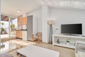 a living room with a tv and a kitchen at Luxury Penthouse apartment Nerja in Nerja