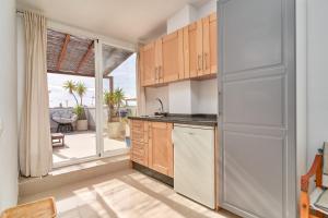 a kitchen with a refrigerator and a large window at Luxury Penthouse apartment Nerja in Nerja