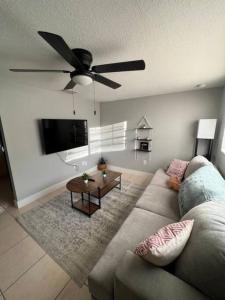 a living room with a couch and a ceiling fan at Busch Gardens Bliss Retreat 1 Bedroom in Tampa