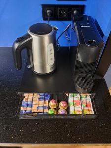 a coffee pot and a box of pastries on a counter at LUX 114 APARTMENT in Košice