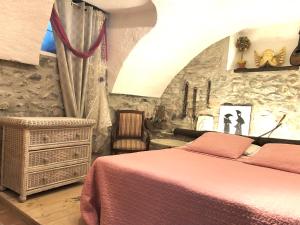 sypialnia z łóżkiem i kamienną ścianą w obiekcie Appartamento Country House Menaggio w mieście Menaggio